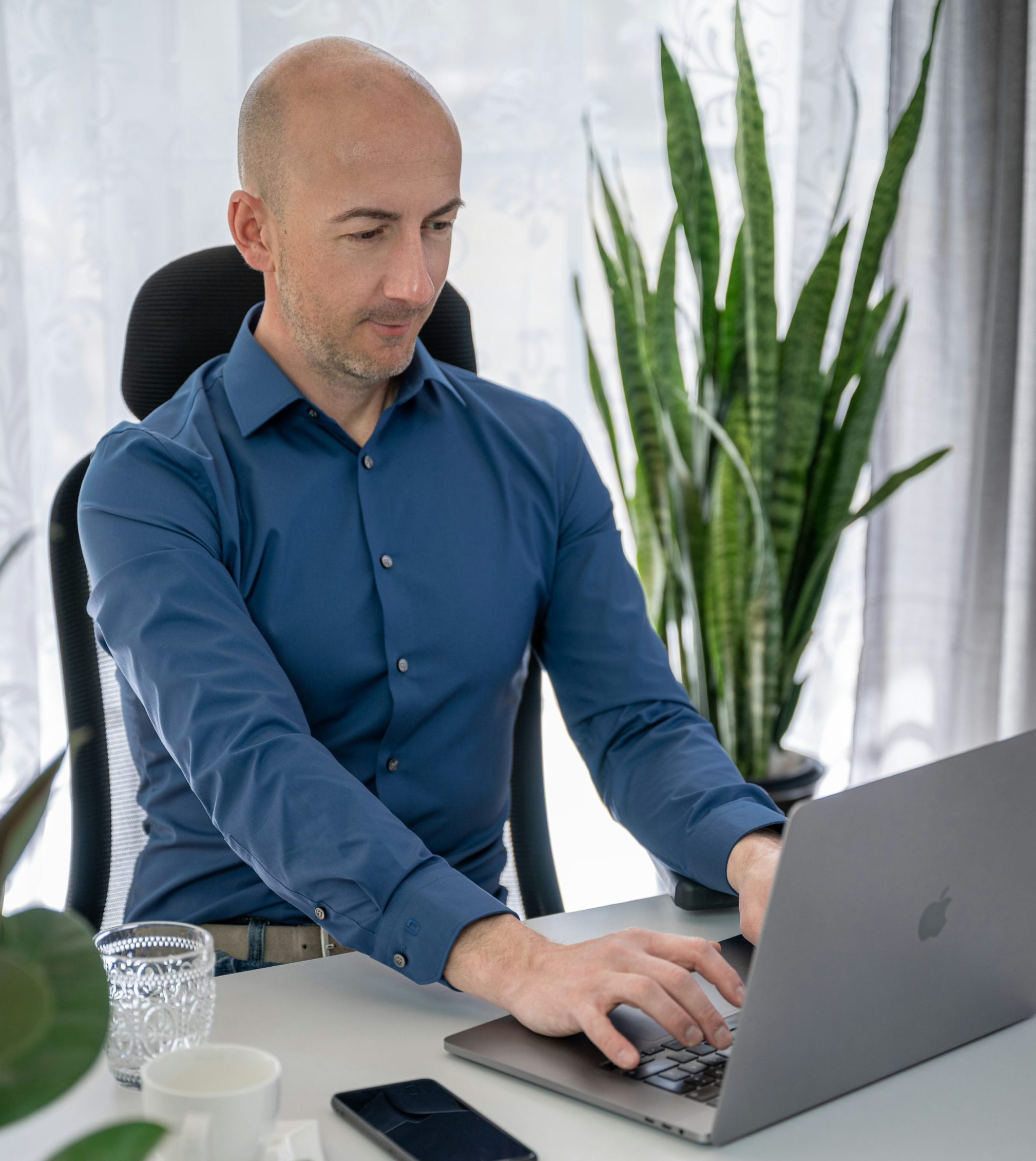Maurus Mayer sitzt am Schreibtisch und tippt in seinen Laptop
